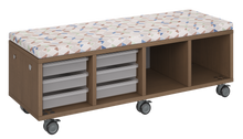 Load image into Gallery viewer, Mobile storage unit with a four column, tray and cubby configuration, optional upholstered seat for seating, customizable laminate finishes, and casters for easy mobility.
